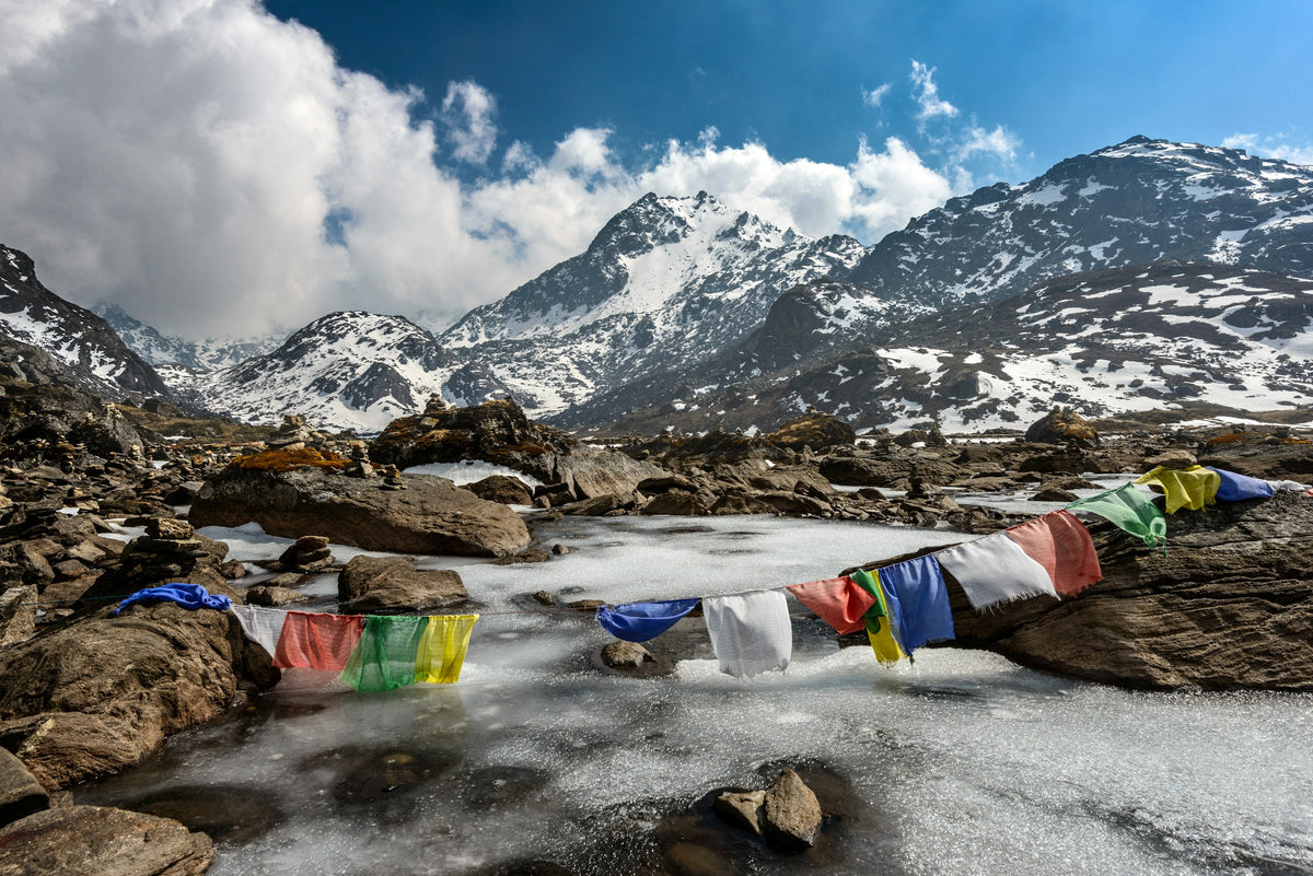 Prayer flags over a frozen mountain lake, Nepal