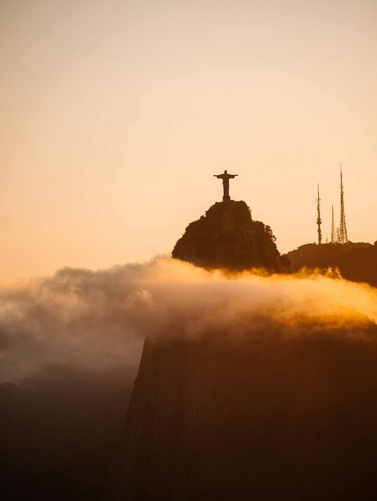 Christ the Redeemer above the clouds at sunset
