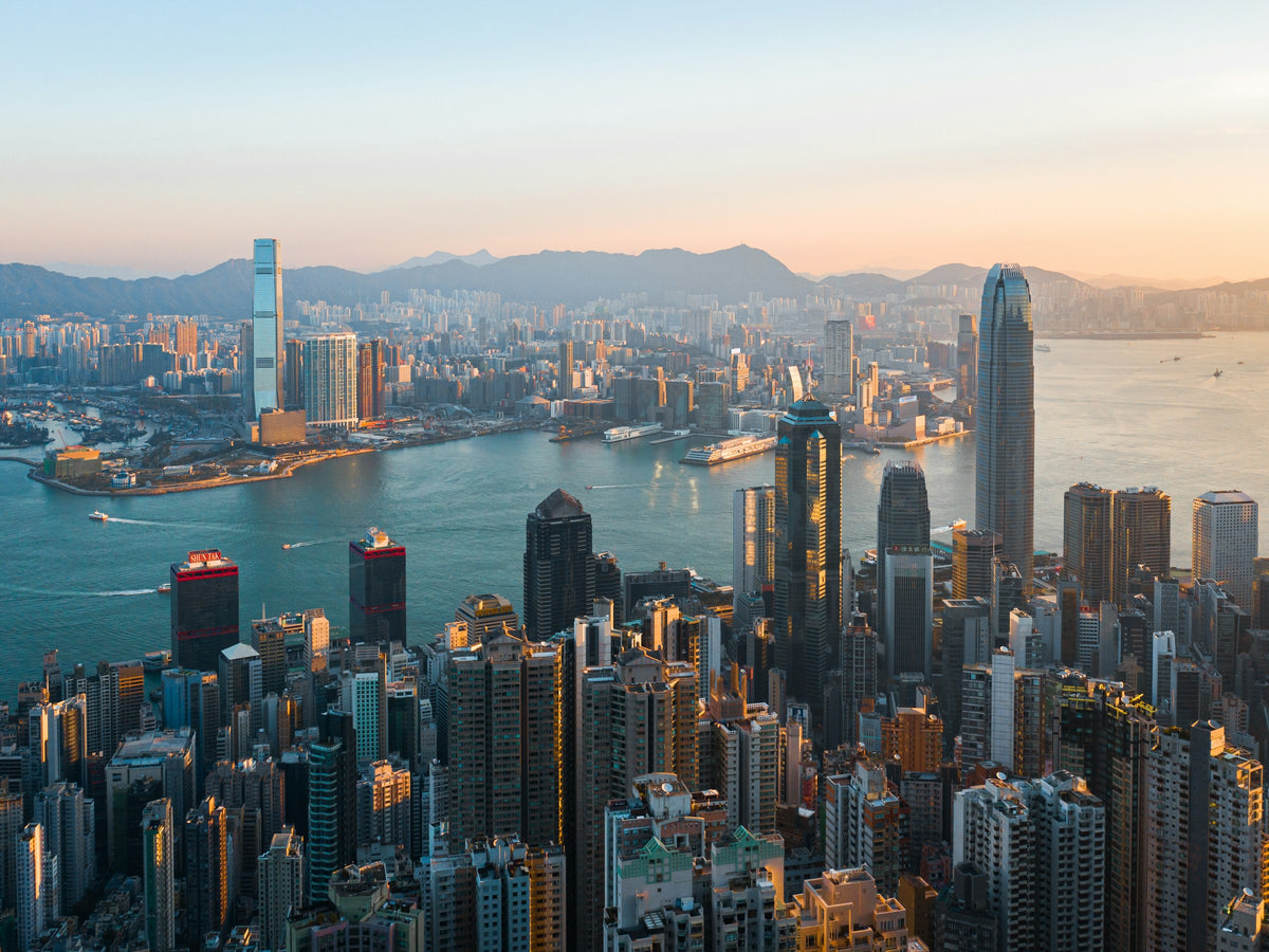 Hong Kong skyline across Victoria Harbour at golden hour