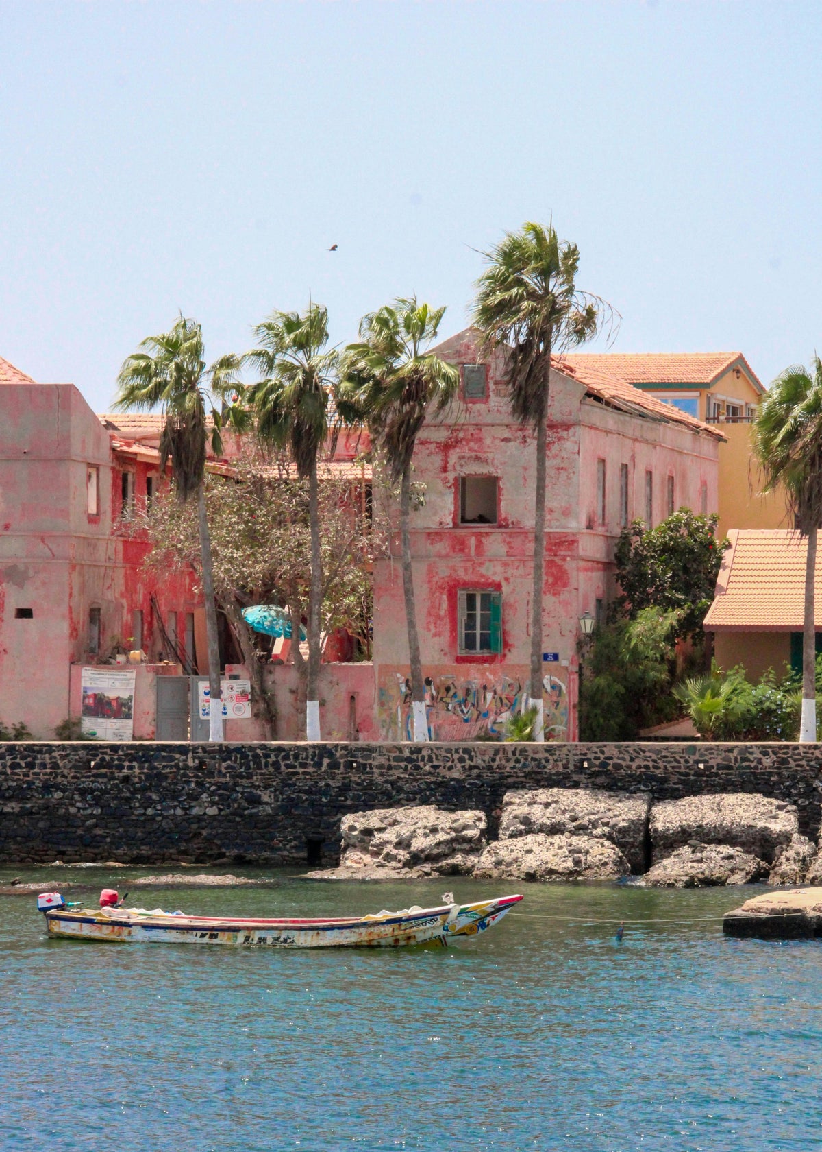 Pink building and palms by the water, Senegal